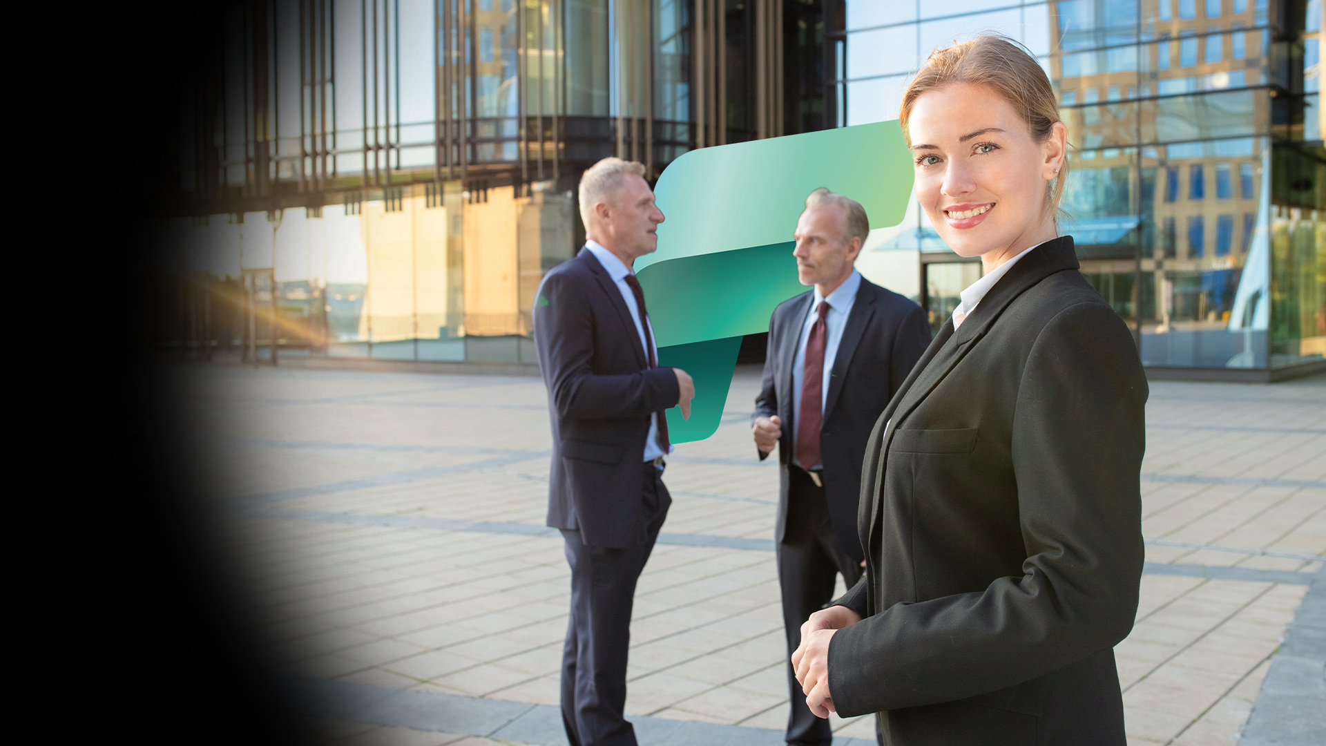 Professional woman in a black suit smiles at the camera outside a glass-office building; two men in suits converse in the background with a green abstract graphic between them.
